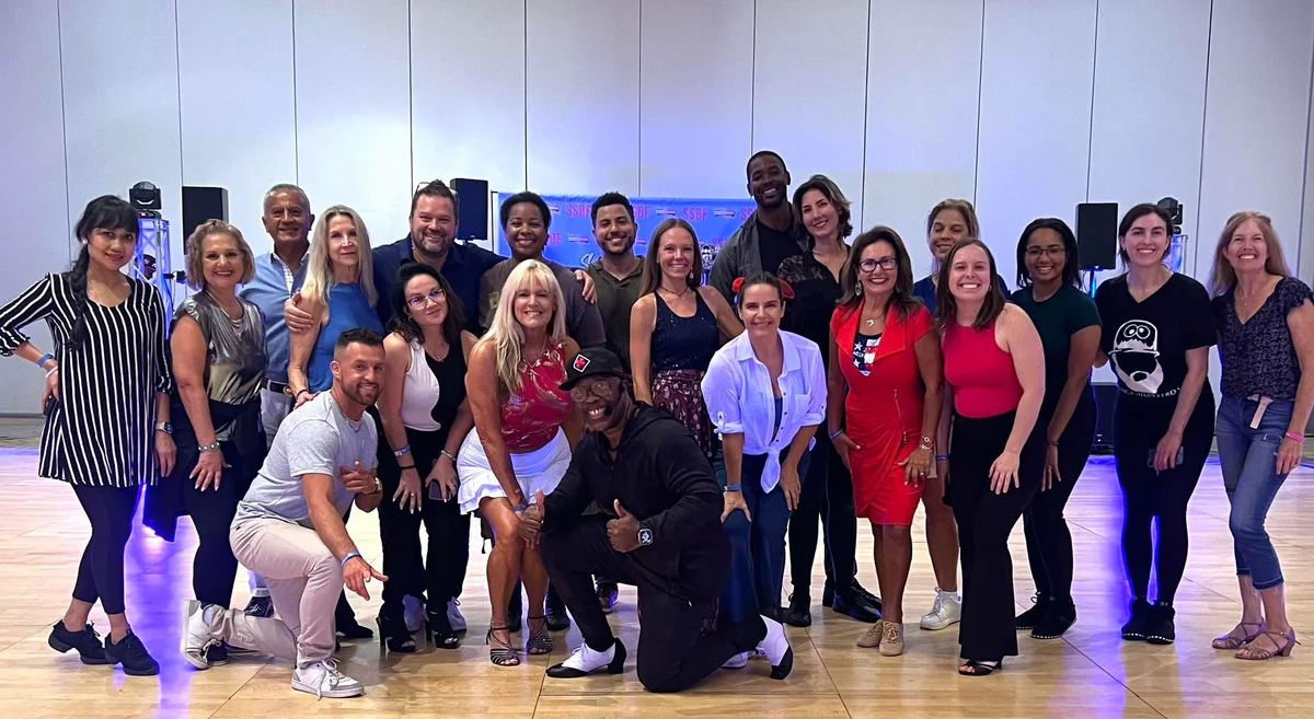A group of dancers smiling together after an event