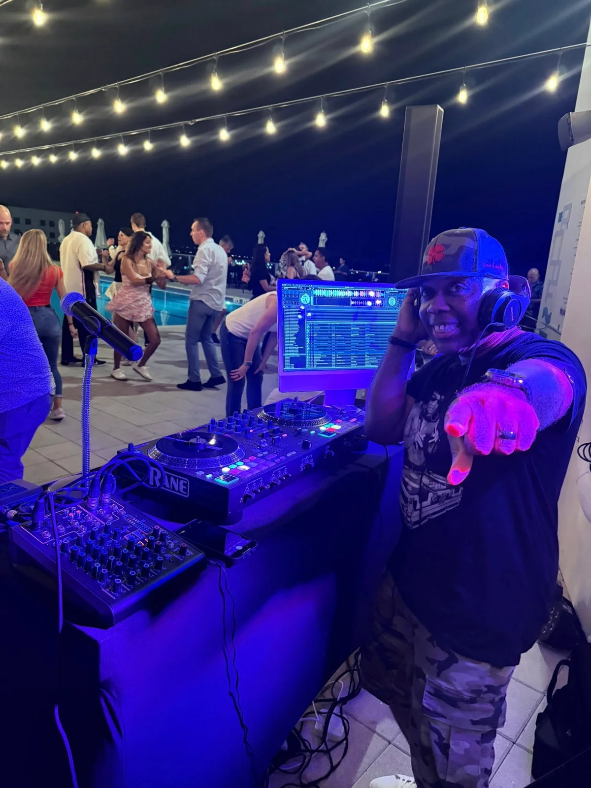 Shacoda DJing an outdoor dance event under string lights