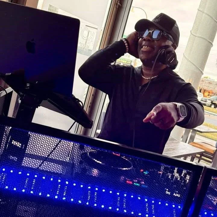 Shacoda smiling behind his DJ equipment